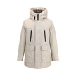Beige Cotton ParkaCotton Ramar Down Jacket by Woolrich, high-necked model with hood, front zipper and button closure, elastic ribbed cuffs, two slit pockets with zipper applied on the front, monochrome padded design, removable patch with iconic brand mono