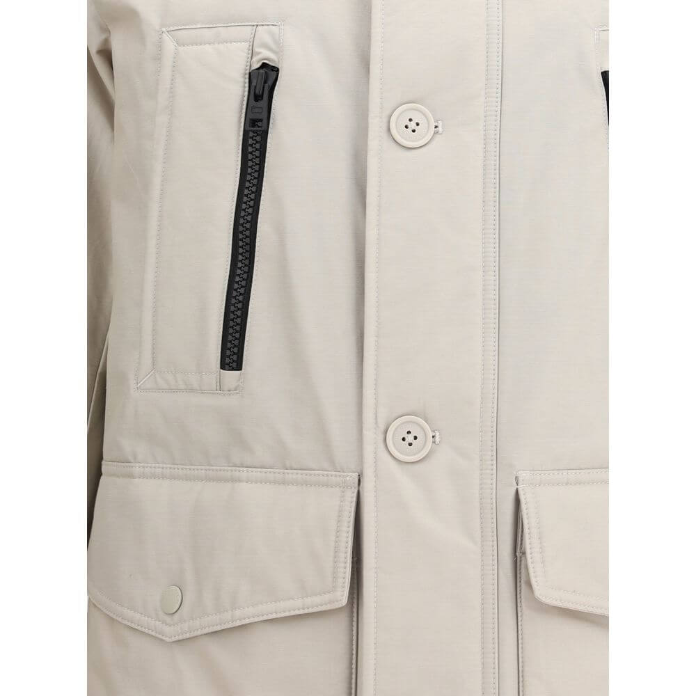 Beige Cotton ParkaCotton Ramar Down Jacket by Woolrich, high-necked model with hood, front zipper and button closure, elastic ribbed cuffs, two slit pockets with zipper applied on the front, monochrome padded design, removable patch with iconic brand mono