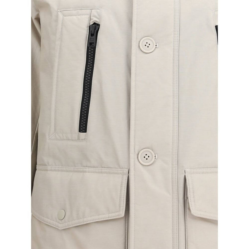 Beige Cotton ParkaCotton Ramar Down Jacket by Woolrich, high-necked model with hood, front zipper and button closure, elastic ribbed cuffs, two slit pockets with zipper applied on the front, monochrome padded design, removable patch with iconic brand mono