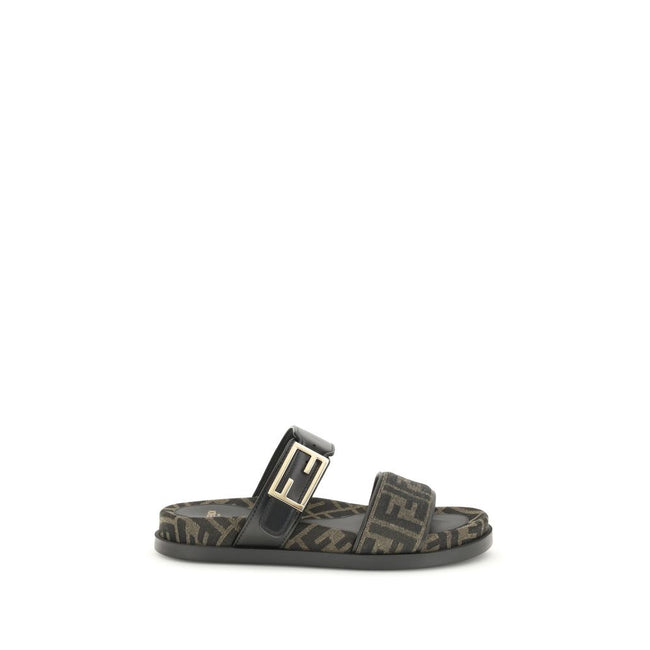 FF fabric sandalThe FF fabric Sandal by Fendi is a flat slide featuring a double strap with a decorative FF Baguette buckle. Crafted in jacquard fabric with the iconic FF pattern and black nappa leather details, it is finished with gold-tone metal hardwar