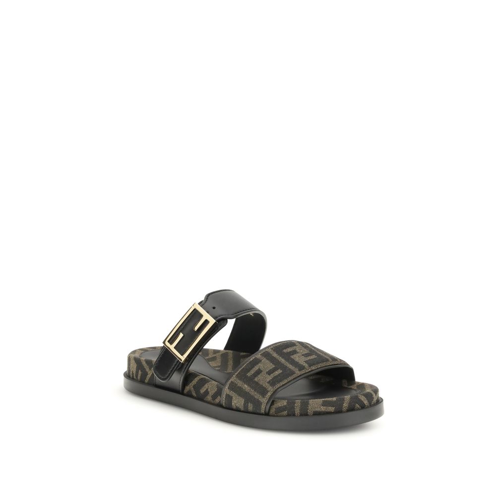 FF fabric sandalThe FF fabric Sandal by Fendi is a flat slide featuring a double strap with a decorative FF Baguette buckle. Crafted in jacquard fabric with the iconic FF pattern and black nappa leather details, it is finished with gold-tone metal hardwar