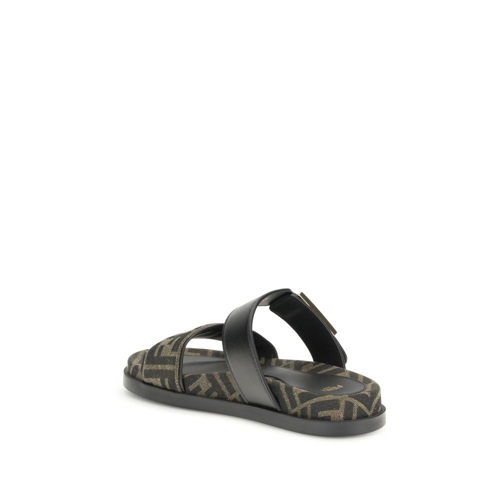 FF fabric sandalThe FF fabric Sandal by Fendi is a flat slide featuring a double strap with a decorative FF Baguette buckle. Crafted in jacquard fabric with the iconic FF pattern and black nappa leather details, it is finished with gold-tone metal hardwar