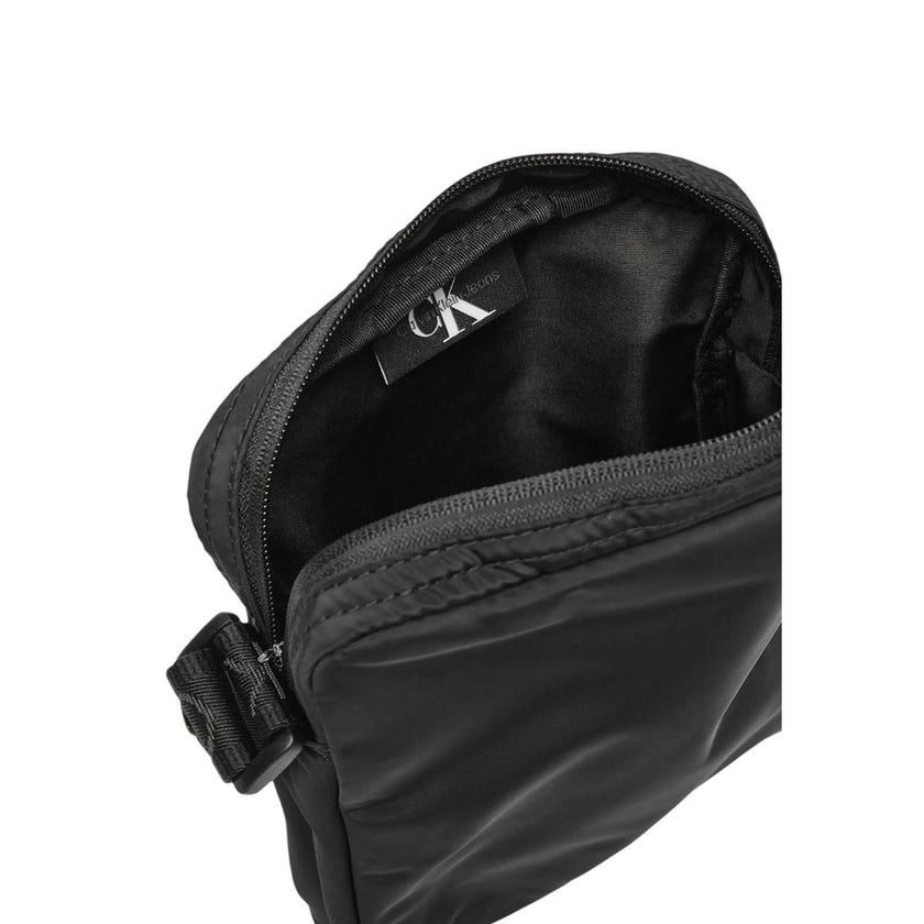 Black Recycled Polyester Messenger BagDiscover the Calvin Klein OVER WEBBING REPORTER18 NY K50K512567 men’s shoulder bag, an elegant and practical accessory for the modern man. Made from 100% recycled polyester, this bag combines sustainability with style
