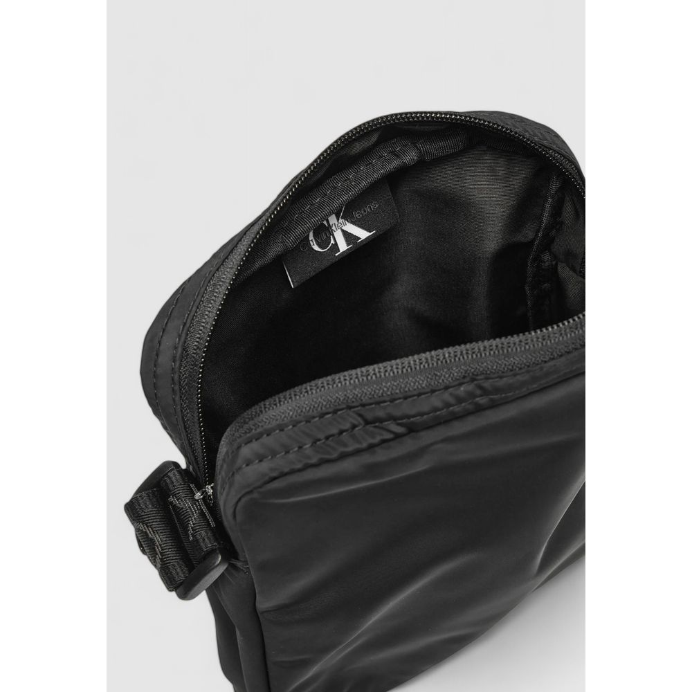 Black Recycled Polyester Messenger BagDiscover the Calvin Klein OVER WEBBING REPORTER18 NY K50K512567 men’s shoulder bag, an elegant and practical accessory for the modern man. Made from 100% recycled polyester, this bag combines sustainability with style