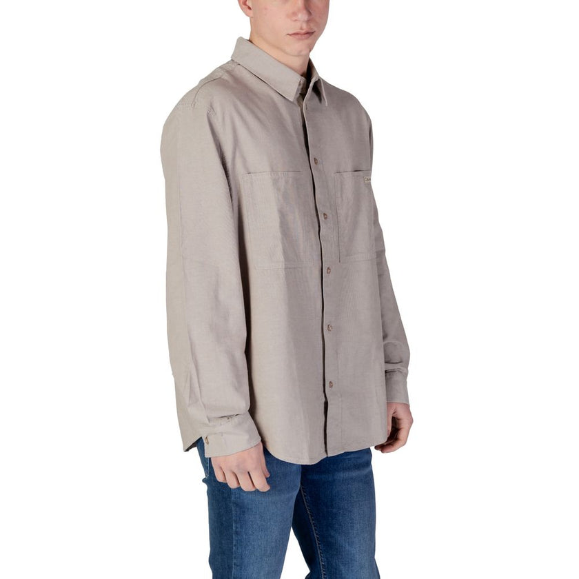Beige Recycled Cotton ShirtThe Calvin Klein Jeans CHAMBRAY J30J326726 men’s shirt is a timeless style choice, ideal for those seeking a casual yet refined look. Crafted from 100% regenerated cotton, this shirt offers both comfort and environmental awarene