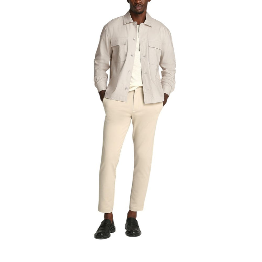 Beige Lyocell ShirtDiscover the long-sleeve men’s shirt by Calvin Klein, a clothing piece that combines elegance and practicality. Made from a refined blend of 51% Lyocell, 47% Linen, and 2% Elastane, this shirt offers exceptional comfort and a perfect fi