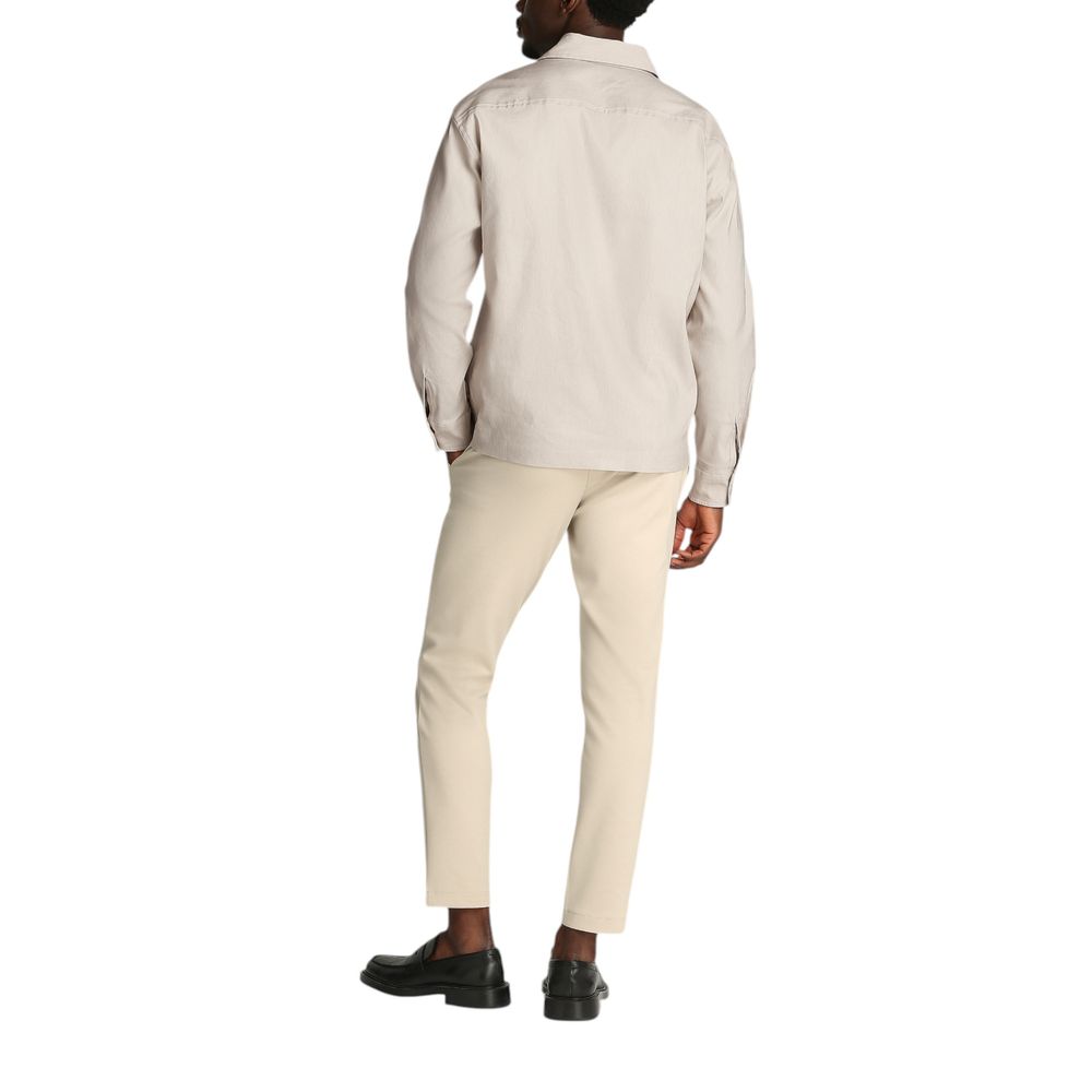 Beige Lyocell ShirtDiscover the long-sleeve men’s shirt by Calvin Klein, a clothing piece that combines elegance and practicality. Made from a refined blend of 51% Lyocell, 47% Linen, and 2% Elastane, this shirt offers exceptional comfort and a perfect fi