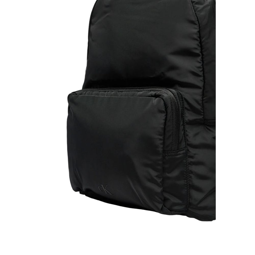 Black Recycled Polyester BackpackDiscover the Ultralight Center Zip backpack by Calvin Klein, a practical and stylish accessory made from 100% recycled polyester. This backpack is designed to provide excellent lightweight functionality without compromisin