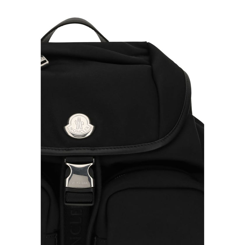 Black Nylon BackpackThe New Trick Backpack by Moncler is designed for everyday use, combining functionality and style. Made from water-repellent recycled nylon with a nylon lining, it features leather finishes and handle, adjustable shoulder straps, and a