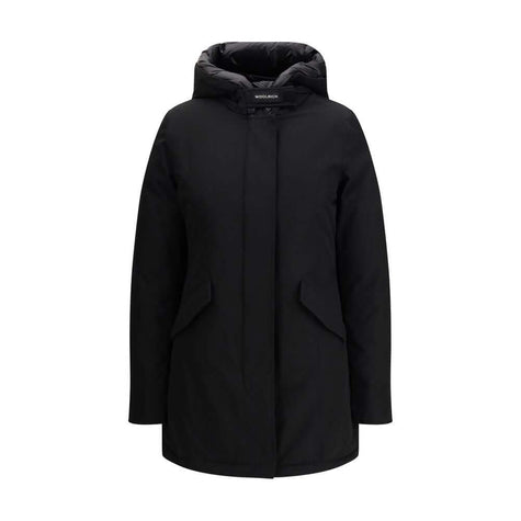 Black Cotton ParkaArctic parka Jacket by Woolrich is made of durable Ramar Cloth fabric, treated with Teflon coating to provide protection from water and wind. Featuring a front zipper and concealed button closure, it has a protective hood, Velcro closure