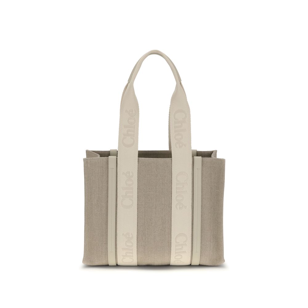 Beige Linen Shoulder BagChloé’s Woody Shoulder Bag by Chloé is crafted from elegant linen with a refined design and distinctive details. Double flat handles are enhanced by contrasting leather extensions on the side panels, while the brand’s iconic monogr