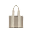 Beige Linen Shoulder BagChloé’s Woody Shoulder Bag by Chloé is crafted from elegant linen with a refined design and distinctive details. Double flat handles are enhanced by contrasting leather extensions on the side panels, while the brand’s iconic monogr