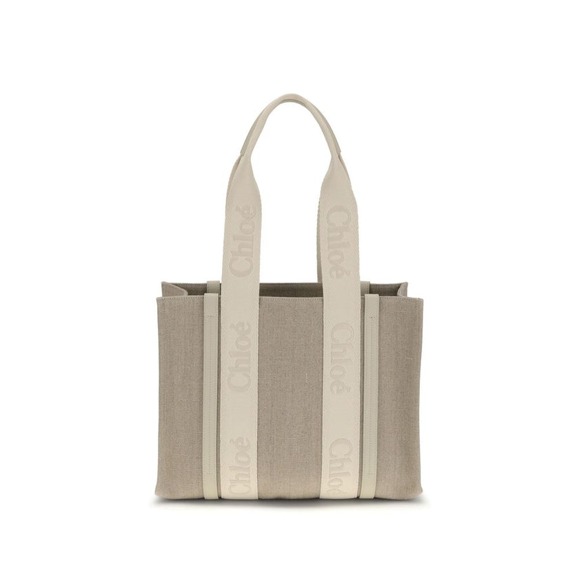 Beige Linen Shoulder BagChloé’s Woody Shoulder Bag by Chloé is crafted from elegant linen with a refined design and distinctive details. Double flat handles are enhanced by contrasting leather extensions on the side panels, while the brand’s iconic monogr