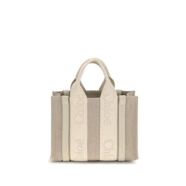 Beige Linen HandbagChloé’s Woody Handbag is an elegant and practical accessory made of linen and detailed with contrasting leather. The concealed button top closure maintains a clean design, while the double flat handles and extension on the leather side