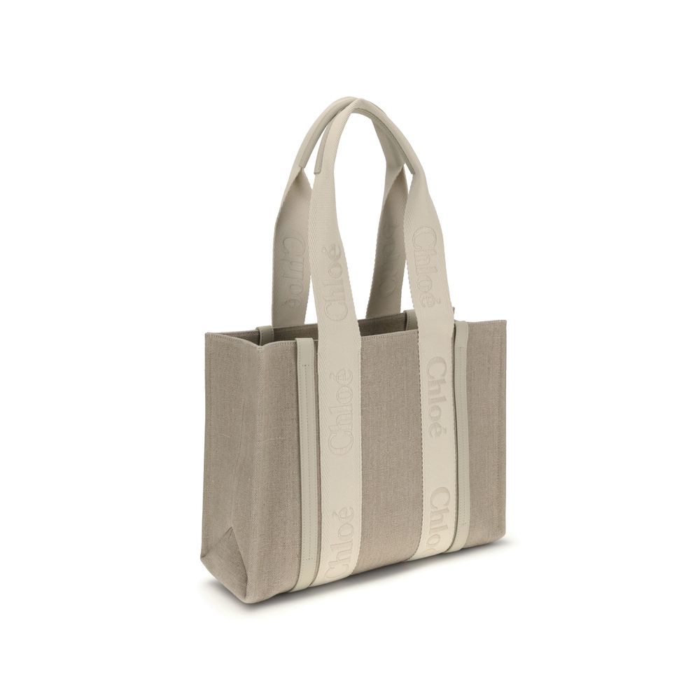Beige Linen Shoulder BagChloé’s Woody Shoulder Bag by Chloé is crafted from elegant linen with a refined design and distinctive details. Double flat handles are enhanced by contrasting leather extensions on the side panels, while the brand’s iconic monogr