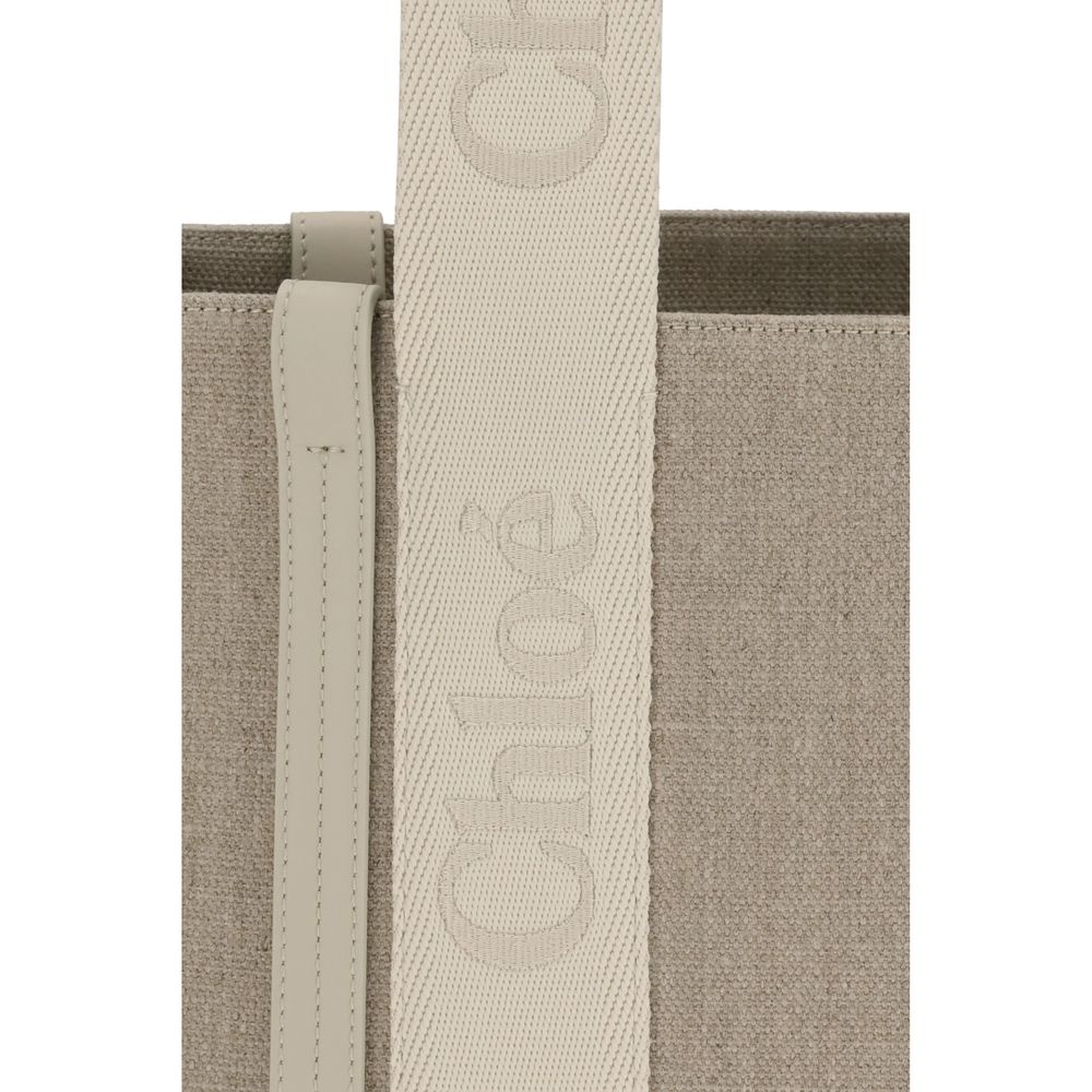 Beige Linen Shoulder BagChloé’s Woody Shoulder Bag by Chloé is crafted from elegant linen with a refined design and distinctive details. Double flat handles are enhanced by contrasting leather extensions on the side panels, while the brand’s iconic monogr