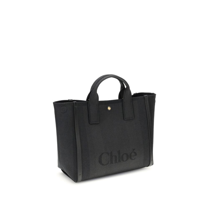 Black Cotton HandbagChloé’s Carry Handbag is a refined and versatile accessory made of cotton with contrasting leather details that accentuate its elegance. The snap top closure provides practicality, while the double flat handles and leather extension on