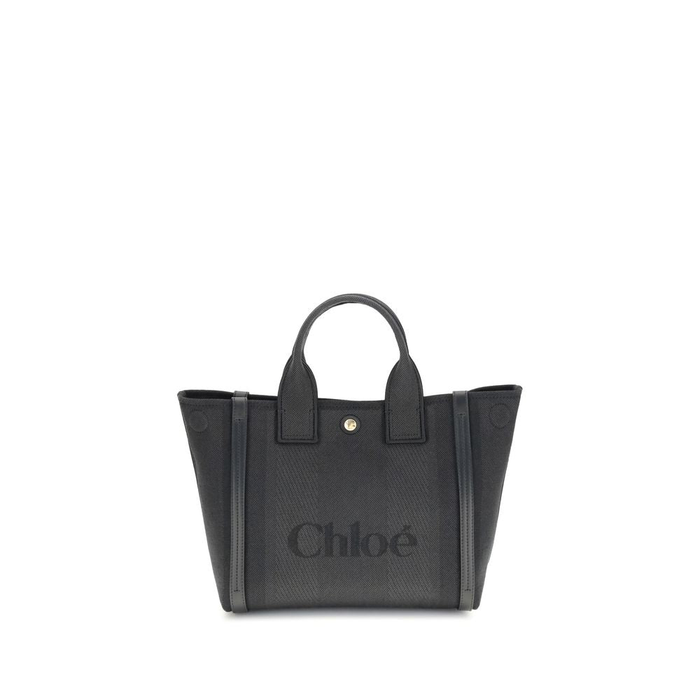 Black Cotton Shoulder BagChloé’s Carry Tote Bag is a stylish, multifunctional accessory made of cotton with contrasting leather details that accentuate its sophisticated appeal. Magnetic buttons on the side panels allow you to adjust the width of the bag
