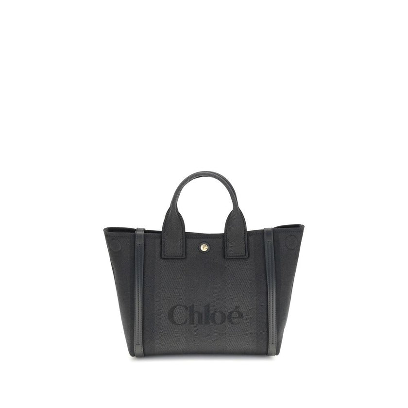 Black Cotton Shoulder BagChloé’s Carry Tote Bag is a stylish, multifunctional accessory made of cotton with contrasting leather details that accentuate its sophisticated appeal. Magnetic buttons on the side panels allow you to adjust the width of the bag
