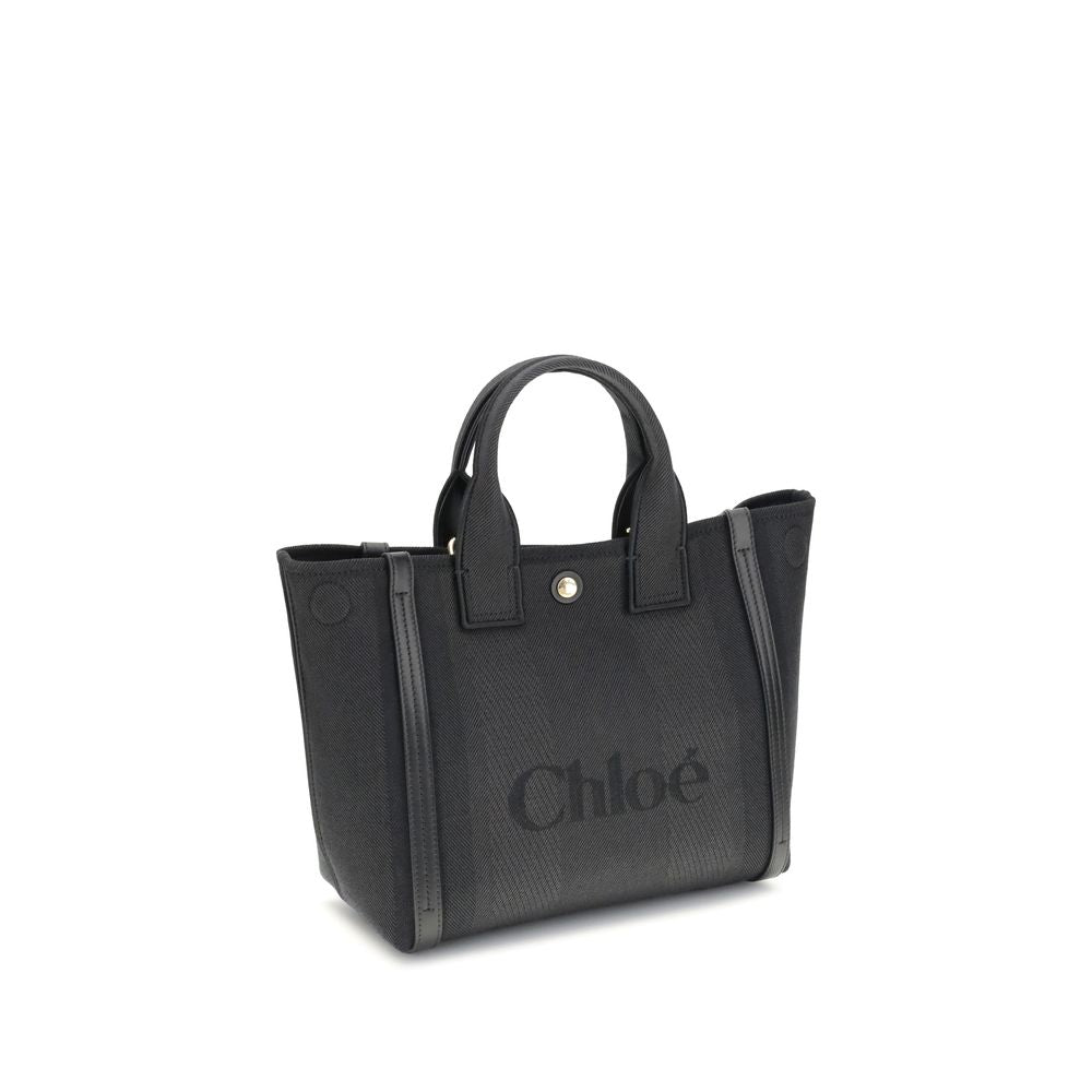 Black Cotton Shoulder BagChloé’s Carry Tote Bag is a stylish, multifunctional accessory made of cotton with contrasting leather details that accentuate its sophisticated appeal. Magnetic buttons on the side panels allow you to adjust the width of the bag