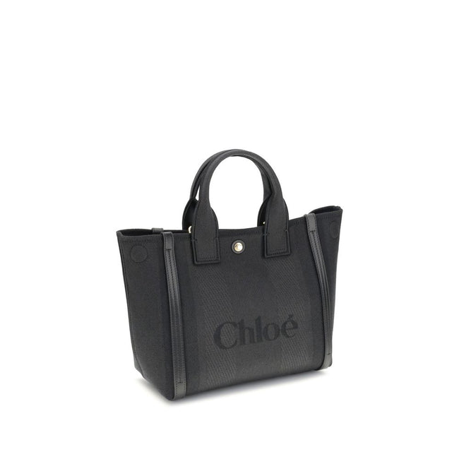 Black Cotton Shoulder BagChloé’s Carry Tote Bag is a stylish, multifunctional accessory made of cotton with contrasting leather details that accentuate its sophisticated appeal. Magnetic buttons on the side panels allow you to adjust the width of the bag