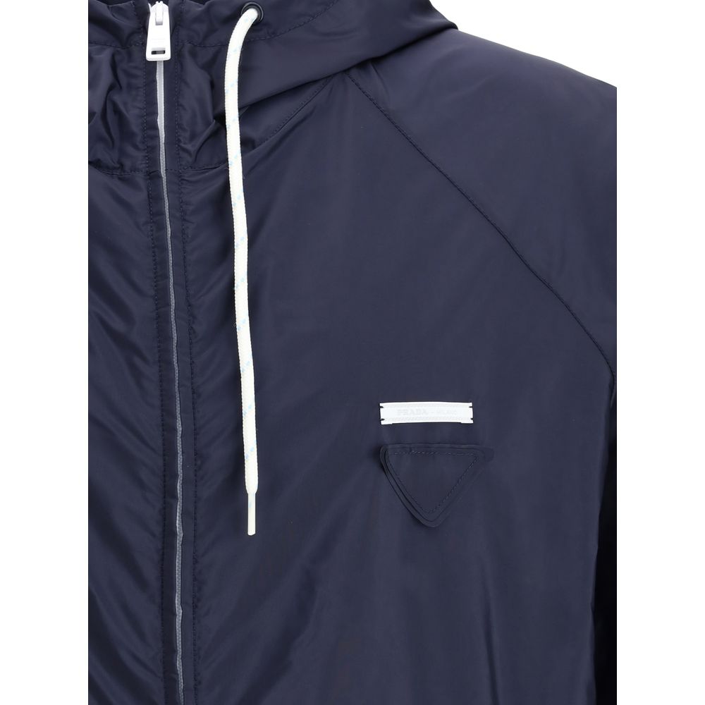 Blue Recycled Polyamide Shell JacketPrada’s Re-Nylon Jacket is a functional and refined garment designed for modern, sustainable elegance. Featuring an adjustable hood with drawstring and front closure with a double-slider zipper, it has two side welt poc