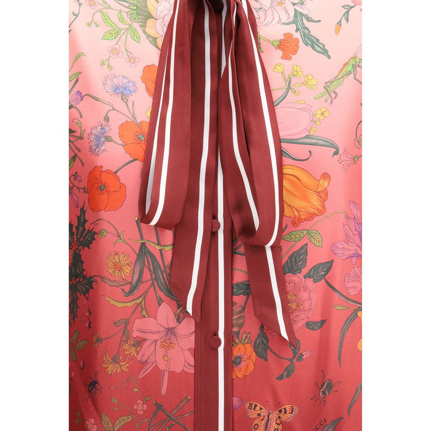Multicolor Silk Pattern ShirtGucci’s Silk Floral Shirt is an elegant and refined piece embellished with a vibrant all-over botanical print. The collar with decorative bow, red piping and hidden buttons enhance the design, while the coordinating cuffs add