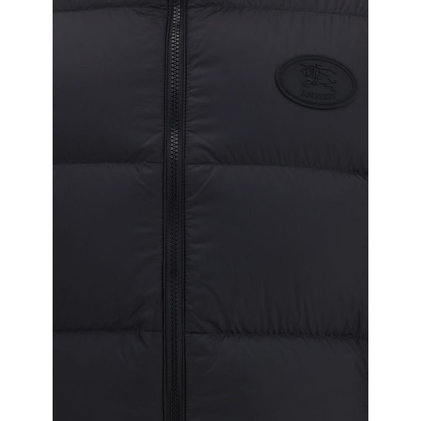 Black Polyester Sleveless JacketThe Reversible Puffer Gilet by Burberry is a versatile piece that combines functionality with iconic style. Padded with goose down and feathers, it ensures warmth and lightness. The reversible design shifts from the signatu