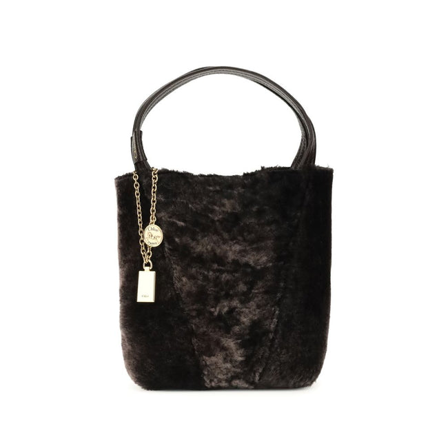 Brown Fur Shoulder BagSpin small Tote Bag by Chloè in soft shearling is distinguished by a compact, minimalist silhouette defined by clean graphic lines. The discreet elegance of the design is enhanced by a dangling chain with the iconic Chloé medals and