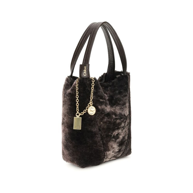 Brown Fur Shoulder BagSpin small Tote Bag by Chloè in soft shearling is distinguished by a compact, minimalist silhouette defined by clean graphic lines. The discreet elegance of the design is enhanced by a dangling chain with the iconic Chloé medals and