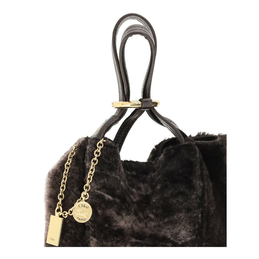 Brown Fur Shoulder BagSpin small Tote Bag by Chloè in soft shearling is distinguished by a compact, minimalist silhouette defined by clean graphic lines. The discreet elegance of the design is enhanced by a dangling chain with the iconic Chloé medals and