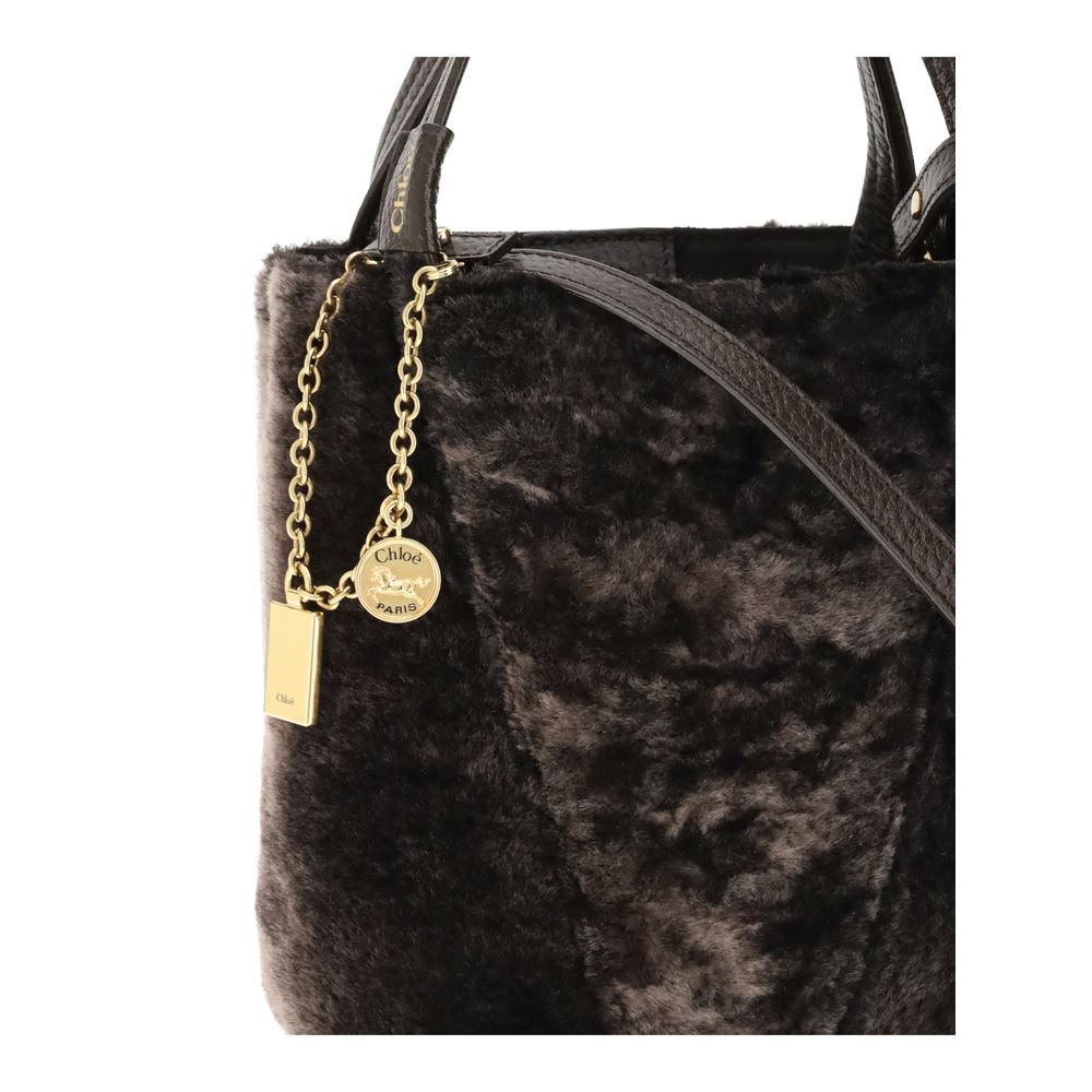 Brown Fur Shoulder BagSpin small Tote Bag by Chloè in soft shearling is distinguished by a compact, minimalist silhouette defined by clean graphic lines. The discreet elegance of the design is enhanced by a dangling chain with the iconic Chloé medals and