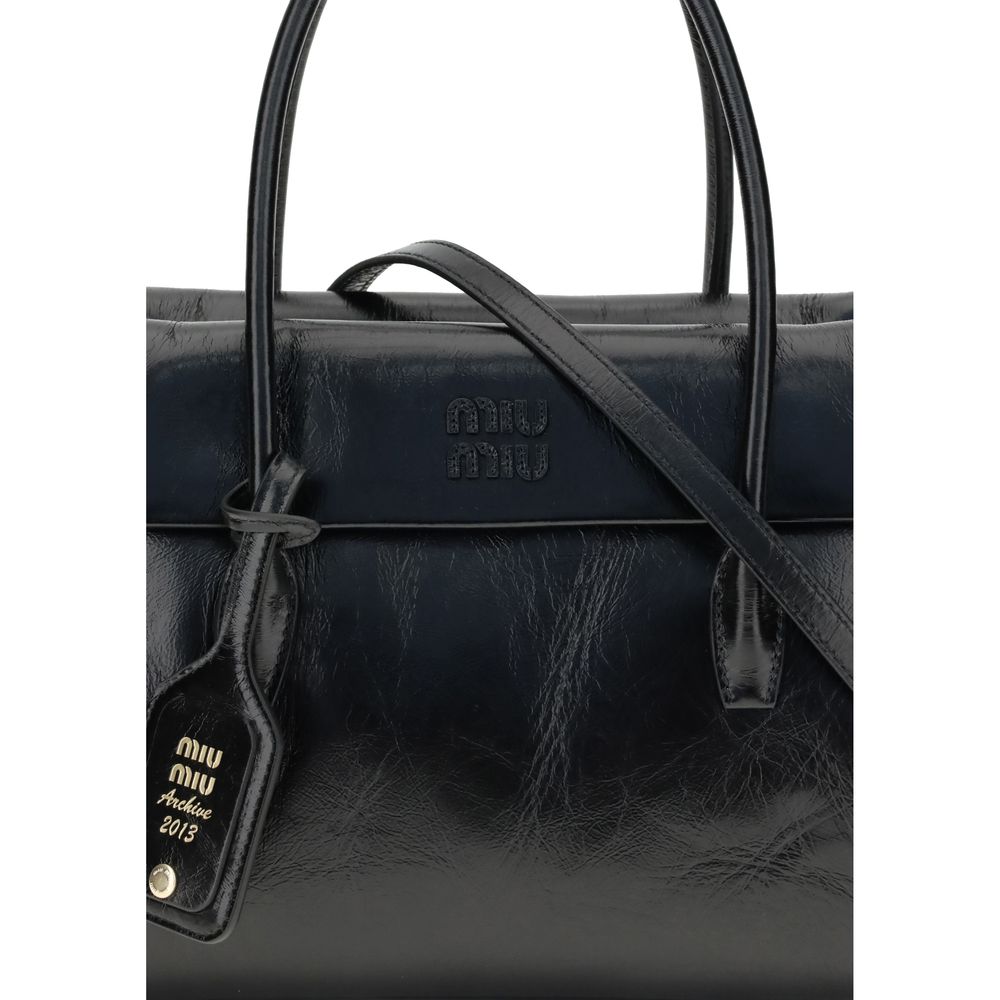 Black Calf Leather Bos Taurus HandbagSolitaire Handbag by Miu Miu combines structured lines and refined details, inspired by the maison’s 2006 archives. Made of shiny calfskin, it blends classic elegance and contemporary spirit, enhanced by the front leat