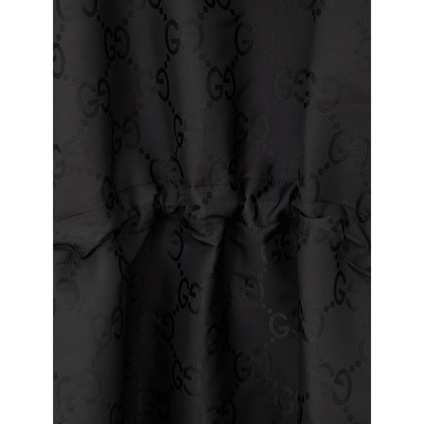Black Polyester Trench CoatBlack Cape with Web Logo and Gucci GG Monogram Print. In black technical fabric, allover logo, maxi contrasting Gucci Web Logo on the front, adjustable hood and half zip on the front. Buttons on the sides to adjust the fit, adju