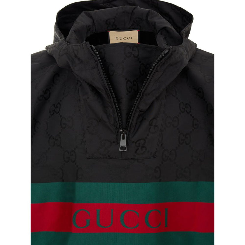 Black Polyester Trench CoatBlack Cape with Web Logo and Gucci GG Monogram Print. In black technical fabric, allover logo, maxi contrasting Gucci Web Logo on the front, adjustable hood and half zip on the front. Buttons on the sides to adjust the fit, adju