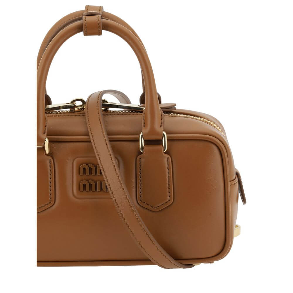 Arcadie HandbagLeather Arcadie Handbag by Miu Miu, double rigid and tubular handles at top, top zipper closure, iconic brand monogram press-stamped on front, single interior compartment, removable and adjustable flat leather shoulder strap. Season: AW25 D