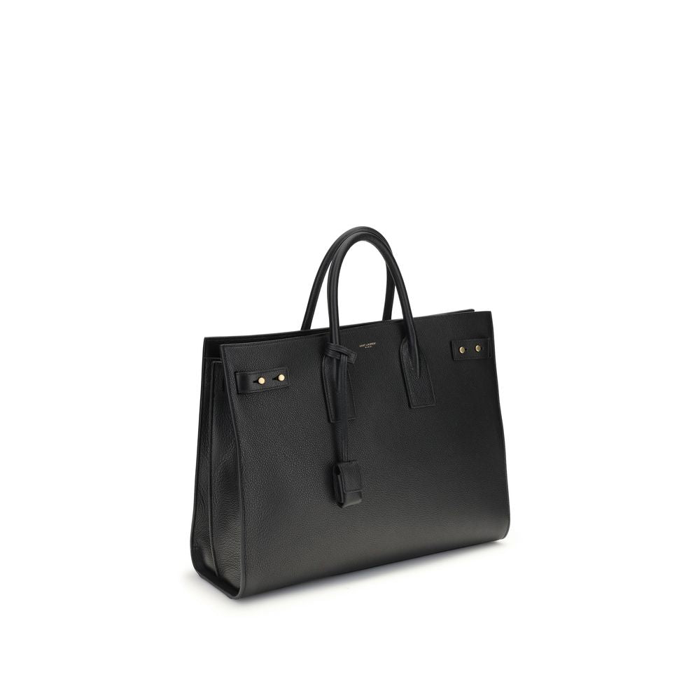 Black Calf Leather Bos Taurus HandbagThe Sac De Jour bag by Saint Laurent combines functionality and style with a soft structure, side gussets, and compression straps with tabs. It features round handles with a lock housed in a removable leather case and