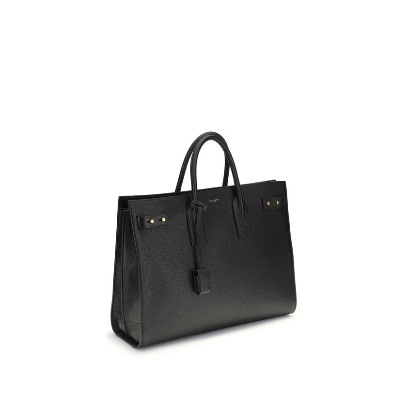 Black Calf Leather Bos Taurus HandbagThe Sac De Jour bag by Saint Laurent combines functionality and style with a soft structure, side gussets, and compression straps with tabs. It features round handles with a lock housed in a removable leather case and