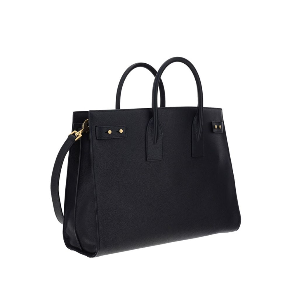 Black Calf Leather Bos Taurus HandbagThe Sac De Jour bag by Saint Laurent combines functionality and style with a soft structure, side gussets, and compression straps with tabs. It features round handles with a lock housed in a removable leather case and