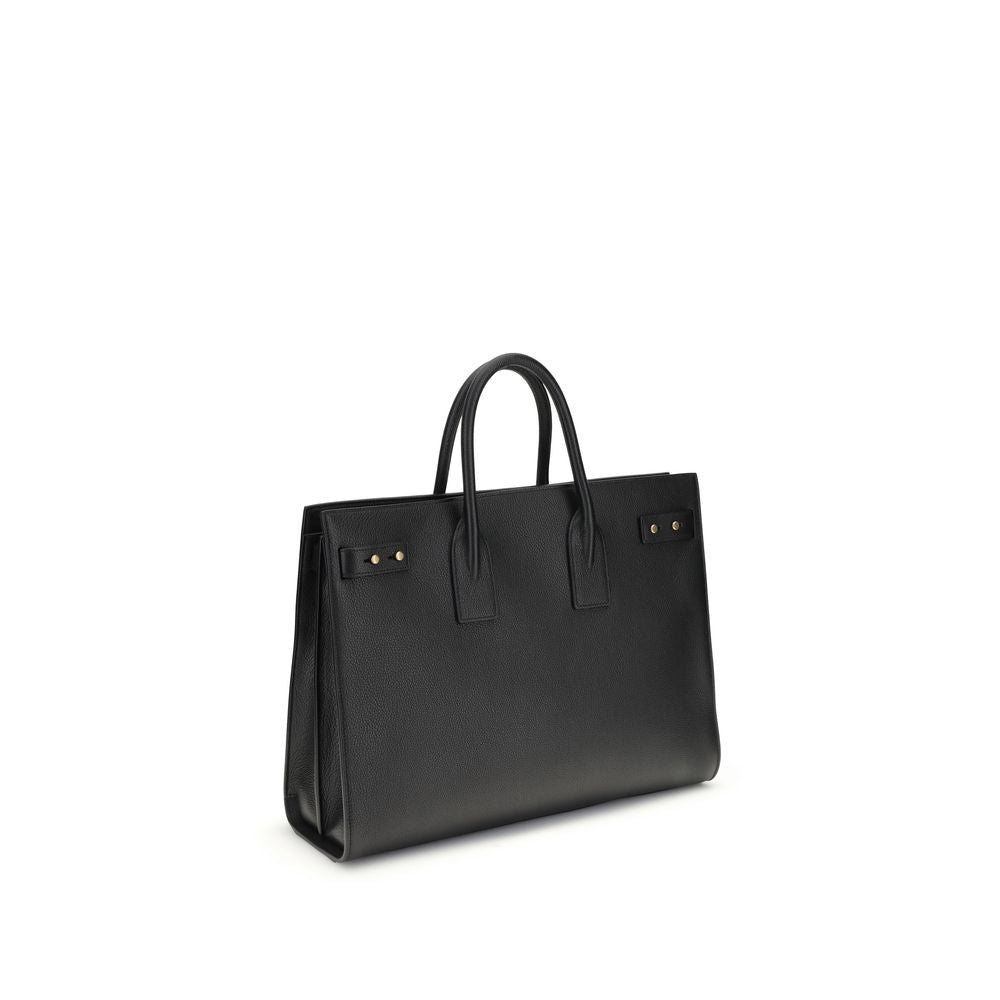 Black Calf Leather Bos Taurus HandbagThe Sac De Jour bag by Saint Laurent combines functionality and style with a soft structure, side gussets, and compression straps with tabs. It features round handles with a lock housed in a removable leather case and