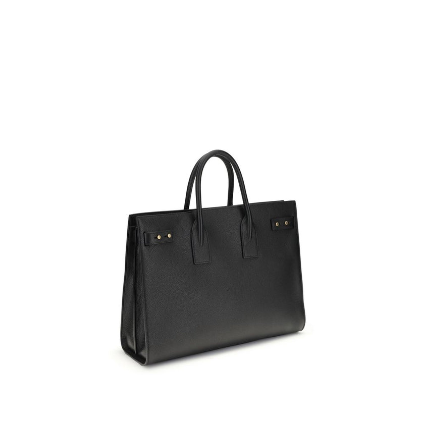 Black Calf Leather Bos Taurus HandbagThe Sac De Jour bag by Saint Laurent combines functionality and style with a soft structure, side gussets, and compression straps with tabs. It features round handles with a lock housed in a removable leather case and