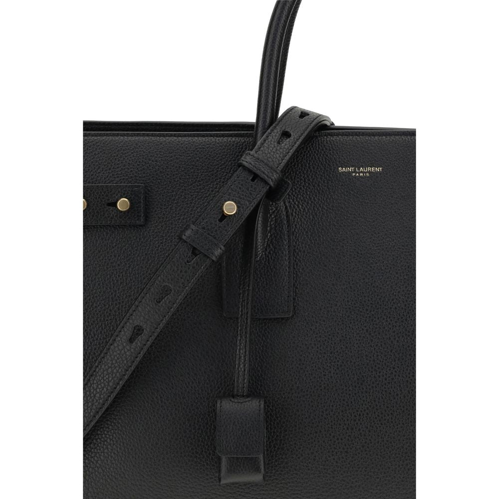 Black Calf Leather Bos Taurus HandbagThe Sac De Jour bag by Saint Laurent combines functionality and style with a soft structure, side gussets, and compression straps with tabs. It features round handles with a lock housed in a removable leather case and