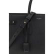 Black Calf Leather Bos Taurus HandbagThe Sac De Jour bag by Saint Laurent combines functionality and style with a soft structure, side gussets, and compression straps with tabs. It features round handles with a lock housed in a removable leather case and