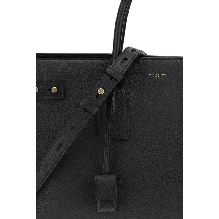 Black Calf Leather Bos Taurus HandbagThe Sac De Jour bag by Saint Laurent combines functionality and style with a soft structure, side gussets, and compression straps with tabs. It features round handles with a lock housed in a removable leather case and