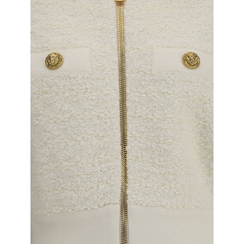 White Viscose BomberThe Tweed Bomber Jacket by Balmain reimagines a sporty classic with the Maison’s unmistakable elegance. Featuring a high collar and batwing long sleeves, it offers volume and modernity, while the decorative side pockets are detailed wi