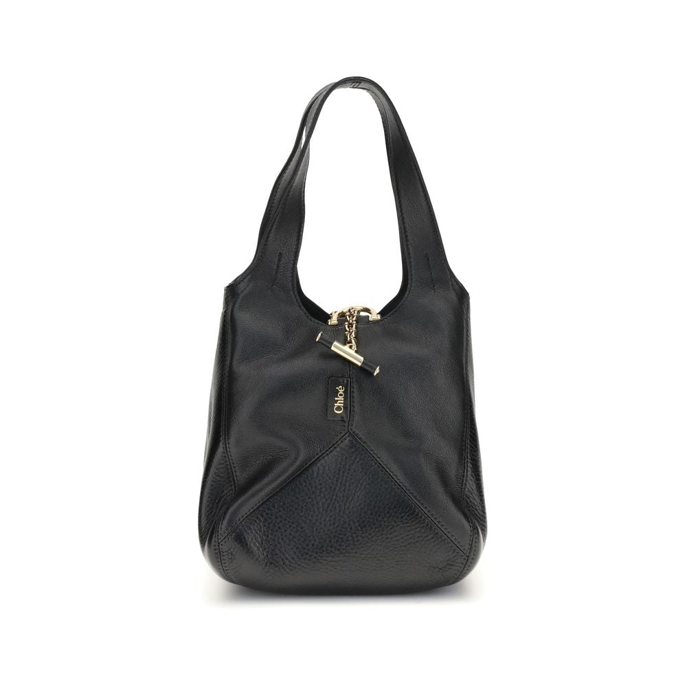Black Buffalo Leather Shoulder BagThe small Balloon Shoulder Bag by Chloé combines elegance and craftsmanship. Crafted from grained buffalo leather with a shiny leather patchwork, it features a main compartment and a toggle closure. It can be carried by h
