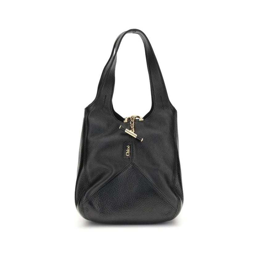 Black Buffalo Leather Shoulder BagThe small Balloon Shoulder Bag by Chloé combines elegance and craftsmanship. Crafted from grained buffalo leather with a shiny leather patchwork, it features a main compartment and a toggle closure. It can be carried by h