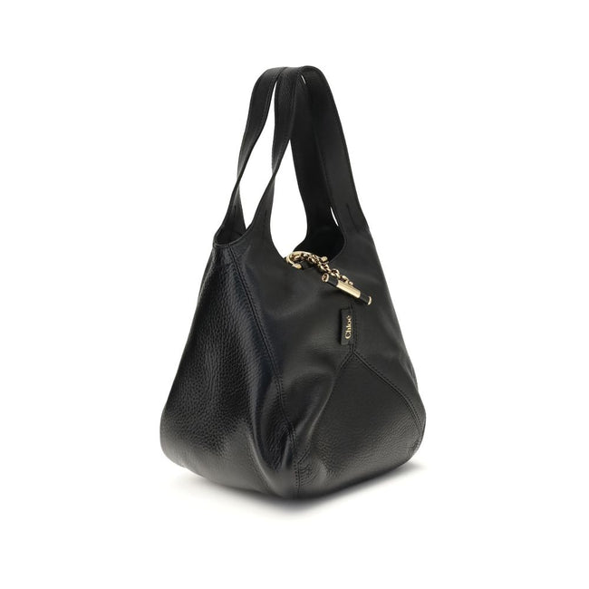 Black Buffalo Leather Shoulder BagThe small Balloon Shoulder Bag by Chloé combines elegance and craftsmanship. Crafted from grained buffalo leather with a shiny leather patchwork, it features a main compartment and a toggle closure. It can be carried by h