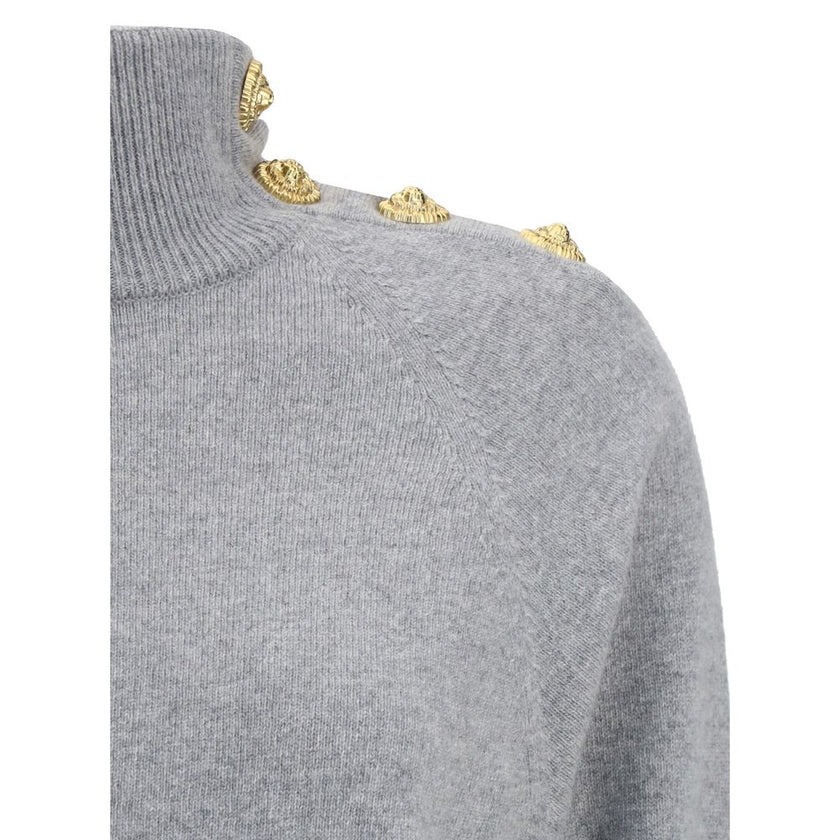 Gray Cashmere Casual DressThe Short Cashmere Sweater Dress by Balmain combines the softness of eco-friendly cashmere with a design of strong character. The high neck is detailed with a four-snap closure concealed under the placket, while decorative “Lion