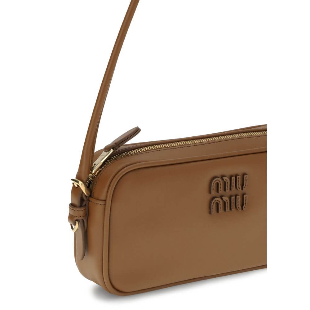 Brown Calf Leather Bos Taurus Shoulder BagShoulder Bag by Miu Miu is an elegant, minimalist accessory made of soft leather and embellished with tonal logo applique on the front, adding a discreet yet distinctive touch. Equipped with a round leather handle